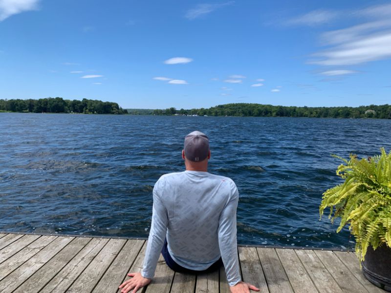 Sean sitting on a dock looking out at the water